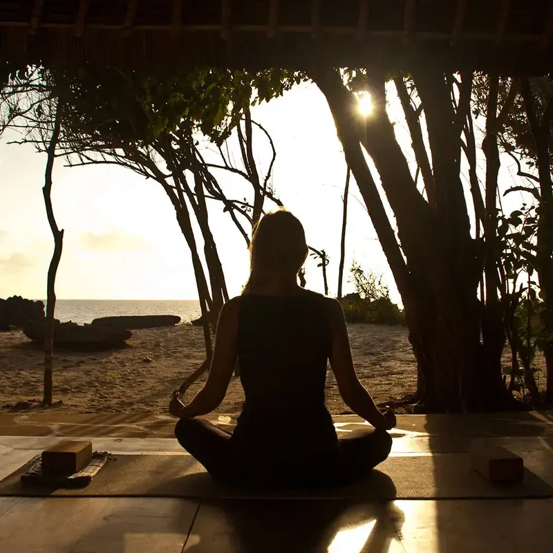 Sesión de yoga al amanecer frente al mar en Kinondo Kwetu
