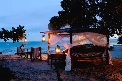 Cama preparada bajo las estrellas junto a la playa en Kinondo Kwetu
