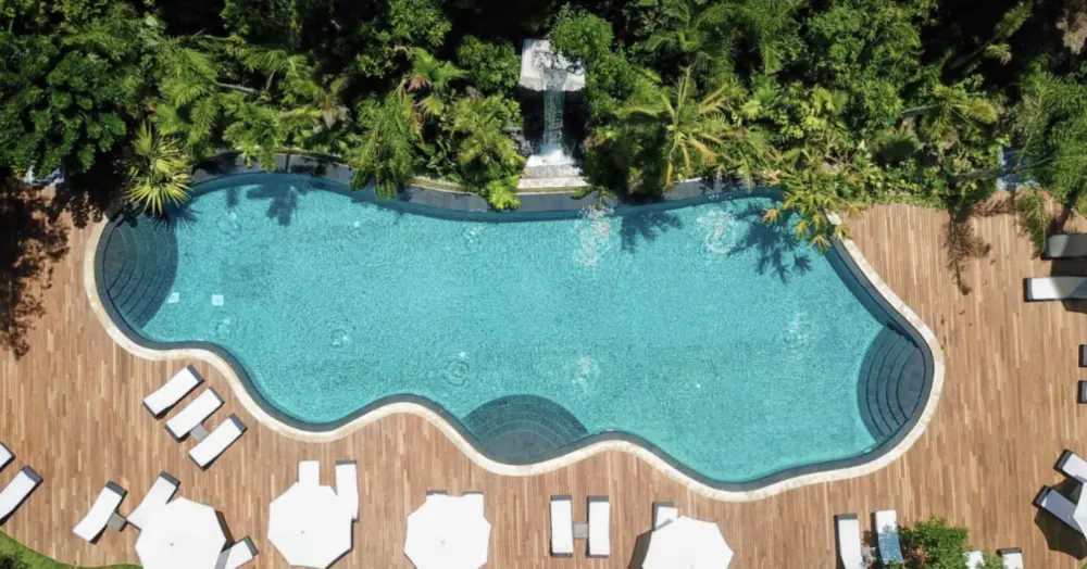 Vista aérea de una piscina rodeada de jardines tropicales en Asia Gardens, Finestrat